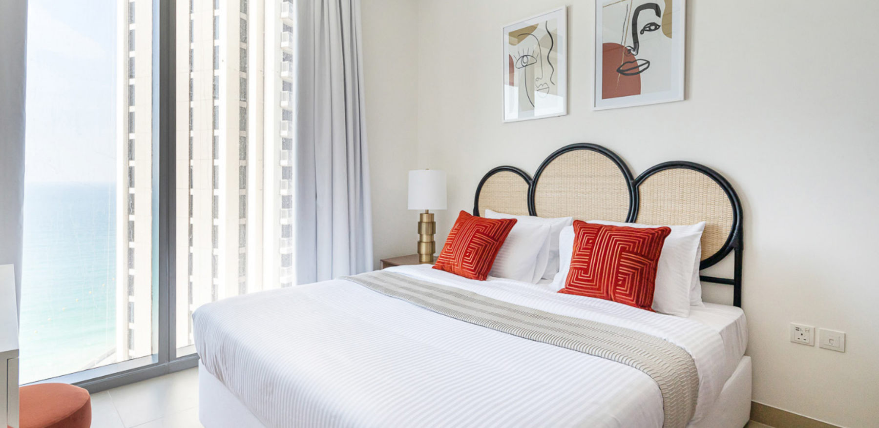 Bedroom with red cushions and rattan headboard